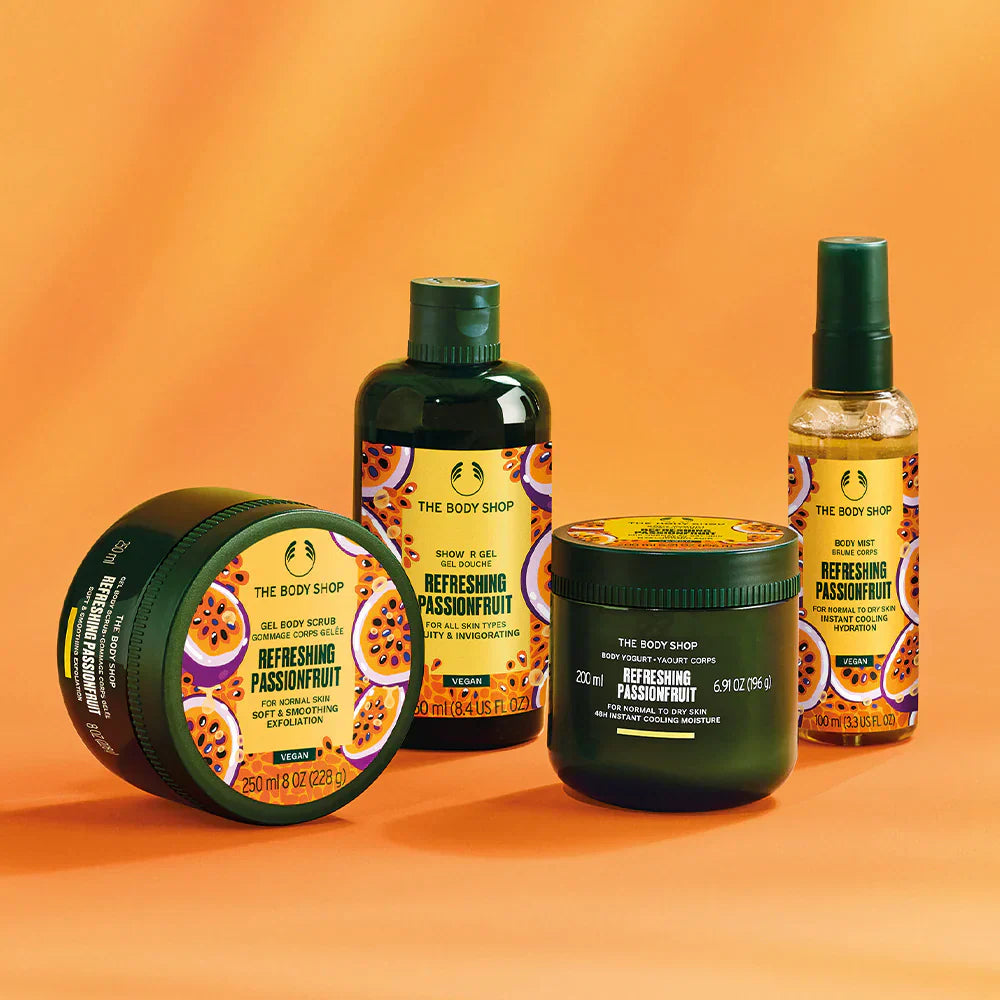 Collection of The Body Shop Refreshing Passionfruit products on an orange background