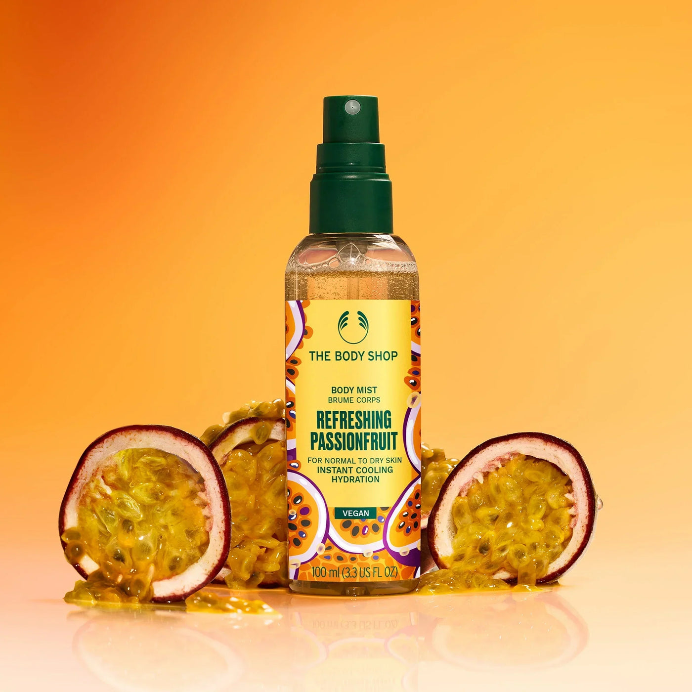 The Body Shop's Refreshing Passionfruit body mist with passionfruit slices on an orange background