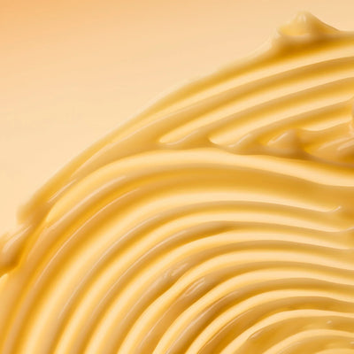 Close-up of smooth, yellow passionfruit yogurt on a beige background